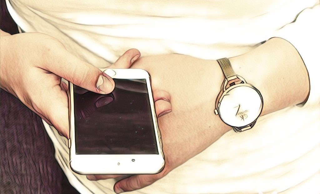 mand med en smartphone og ur på håndleddet